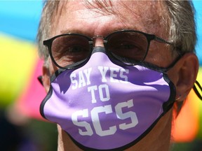 Supporters wear masks at a rally in Central Park in downtown Calgary to show support for the safe consumption site Saturday, June 26, {iptcyear4 Jim Wells/Postmedia