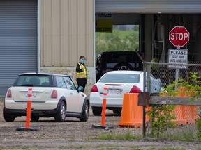 Cars are directed into a drive-thru COVID-19 vaccination centre that opened in the previous drive-thru testing location on 32nd Avenue N.E. on Monday, June 7, 2021.