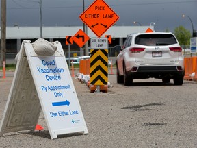 Cars head into a drive-thru COVID-19 vaccination centre that opened in the previous drive-thru testing location on 32nd Avenue N.E. on Monday, June 7, 2021.