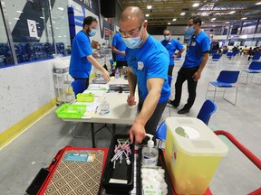 Staff prepare supplies at the pop-up COVID-19 vaccination clinic at the Village Square Leisure Centre in northeast Calgary on Sunday, June. 6, 2021. 
Gavin Young/Postmedia