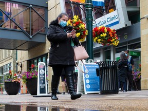 Calgarians walk past the downtown COVID-19 vaccination clinic on Thursday, June 24, 2021.