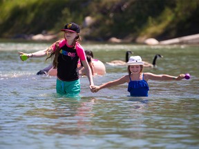 Kids cools off in the lagoon at St. Patrick’s Island on another heat wave day in Calgary, Tuesday, June 29, 2021.