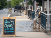 A man washes the sidewalk ahead of the opening of restaurant patios in Kingston this week.