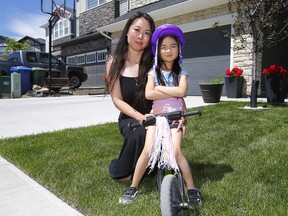 Mom, Nicole Au and her daughter Jadenn, 5, out front of their Nolan Hill home where Nicole was attacked by a coyote when the two were heading out for a walk last week in Calgary on Monday, June 21, 2021.