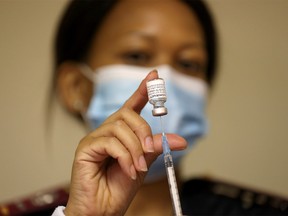 FILE PHOTO: A health worker holds a vial of the Pfizer/BioNTech coronavirus disease (COVID-19) vaccine, at the Munsieville Care for the Aged Centre outside Johannesburg, South Africa May 17, 2021.