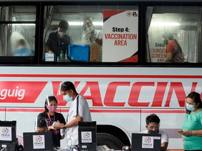 FILE PHOTO: Health workers encode information and prepare vaccines against the coronavirus disease (COVID-19) at a mobile vaccination site in Taguig, Metro Manila, Philippines, May 21, 2021.