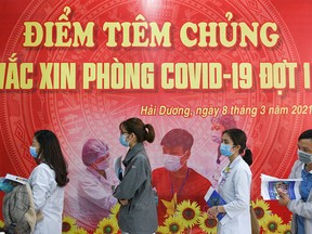 FILE PHOTO: Health workers wait for their turn as Vietnam starts its official rollout of AstraZeneca's coronavirus disease (COVID-19) vaccine for health workers, at Hai Duong Hospital for Tropical Diseases, Hai Duong province, Vietnam, March 8, 2021.