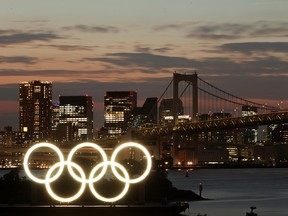 A general view of the Olympic rings installed on a floating platform with the Rainbow Bridge in the background in preparation for the Tokyo 2020 Olympic Games in Tokyo on June 21, 2021.