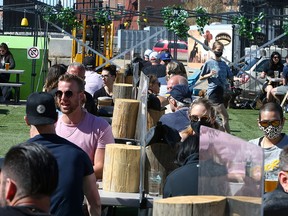 Customers separated by plexiglass enjoy the patio at the Cold Garden Beverage Company in Inglewood on April 30, 2021.