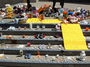 Children's shoes and stuffed animals are placed on the steps of Calgary City Hall on June 1, 2021, to commemorate the discovery of 215 children found buried at a former residential school in Kamloops, B.C.