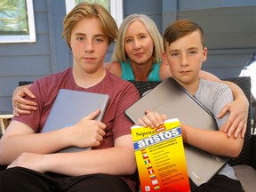 Mom, Tabitha Beaton with her two sons (L-R), Jack, 15 and Evan, 13, says she was not heard during the CBE's engagement process and now her boys will not be able to continue their Spanish bilingual program (currently at Dr. E.P. Scarlett) unless they travel all the way to Crescent Heights, which will be the only school offering it by 2022. Photo taken in Calgary on Wednesday, June 30, 2021.