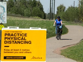 A woman is seen on her bicycle in Fish Creek Park during a hot day. Thursday, June 3, 2021.