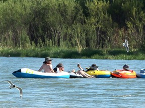 People are seen tubing down the Bow River on a hot day. Thursday, June 3, 2021.