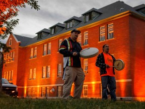 Thundersky Justin Young, left, and Daryl Laboucan drum and sing healing songs at a makeshift memorial to honour the 215 children whose remains have been discovered buried near the former Kamloops Indian Residential School in Kamloops, British Columbia, Canada, on June 2, 2021.