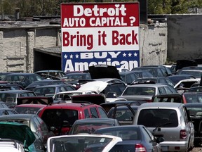 A 'Buy American' sign, in support of Detroit's auto industry, is seen in the back of an auto scrap yard in Detroit, Michigan in 2009. Automotive manufacturing is likely to see the most significant changes in a century as batteries and motors gradually replace conventional engines that combust gasoline during the next decade.