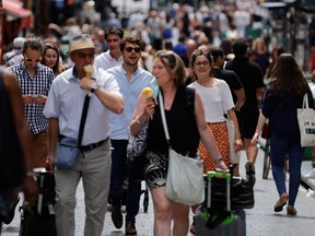 People walk in a street in Paris without protective face masks as they are no longer required outdoors, amid the coronavirus disease (COVID-19) pandemic, France, June 17, 2021.