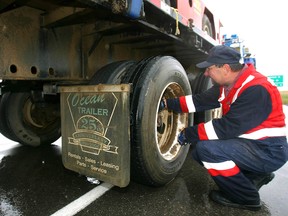 Calgary Police safety inspector Dave Sharek checks the wheels of a transport truck during a checkstop in Calgary on Sept. 16, 2010.