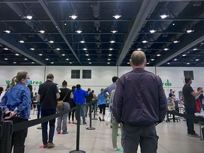 People line up to be vaccinated at the downtown Calgary COVID-19 vaccination clinic on Friday, June 11, 2021.