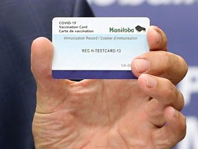 Premier Brian Pallister holds a vaccination card during a press briefing on vaccine measures at the Manitoba Legislative Building in Winnipeg on June 8, 2021. (file photo)