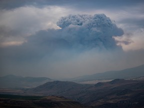 A pyrocumulus cloud, also known as a fire cloud, forms in the sky as the Tremont Creek wildfire burns on the mountains above Ashcroft, B.C., on Friday, July 16, 2021.