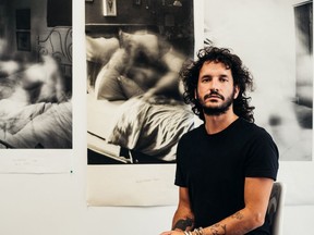 Calgary photographer Sebastian Buzzalino in front of his work from the exhibit Little Deaths. Photo by Sebastian Buzzalino.