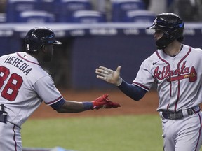 MIAMI, FL - JULY 11: Dansby Swanson #7 of the Atlanta Braves is congratulated by Guillermo Heredia #38 after hitting a home run in the sixth inning against the Miami Marlins at loanDepot park on July 11, 2021 in Miami, Florida.