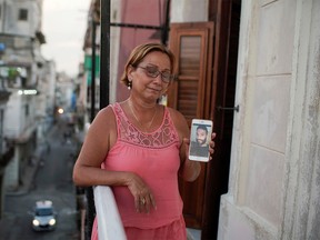 Raisa Gonzalez reacts as she shows a picture of her son Angelo Troya Gonzalez, an artist sanctioned after protests, in Havana, Cuba, July 20, 2021.