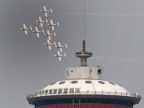 The Snowbirds streak past the Calgary Tower during a flyover on Wednesday, July 14, 2021.