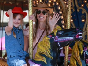 Isla Huston, 6, has fun riding the carousel with her mom Elyce at the Calgary Stampede on Saturday, July 17, 2021.