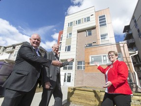 Alan Norris, chair of the Resolve Campaign and president and CEO of Brookfield Residential Properties, with Scott Haggins, president of Cedarglen Living Inc., and Diana Krecsy, CEO of the Calgary Homeless Foundation, outside the new Stepping Stone Manor project at 222 15 Ave. S.W.