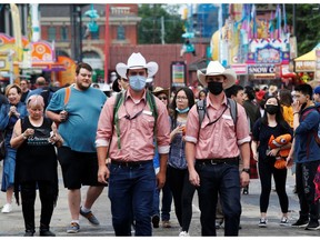 Calgary Stampede workers walk wearing masks on the midway as the Calgary Stampede gets underway following a year off due to coronavirus disease (COVID-19) restrictions, in Calgary, Alberta, Canada on July 11, 2021.
