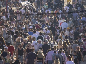 Shot with a telephoto lens, the midway appears packed at the Calgary Stampede on Saturday, July 10, 2021.