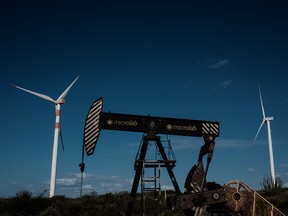 An oil drilling platform is seen next to wind turbines at Vamcruz Windfarm in Serra do Mel, Rio Grande do Norte State, Brazil.