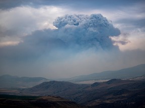 A pyrocumulus cloud, also known as a fire cloud, forms in the sky as the Tremont Creek wildfire burns on the mountains above Ashcroft, B.C., on Friday, July 16, 2021.