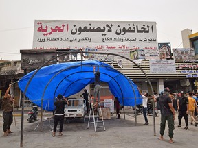 Iraqi protesters erect a tent at al-Haboubi Square in the southern city of Nasiriyah in Dhi Qar province on July 13, 2021, after fire swept through a COVID isolation unit killing more than 90 people in the city's Al-Hussein Hospital.