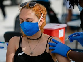 A woman receives a shot of Johnson & Johnson COVID-19 vaccine at a pop-up vaccination centre at the beach, in South Beach, Florida, on May 9, 2021.