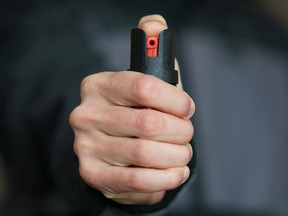 Photo-illustration of a man holding pepper spray.