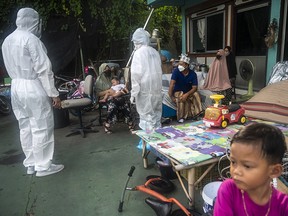 A response team of speaks to a family of patients after giving them an oxygen saturation reading on July 16, 2021, in Bangkok, Thailand.
