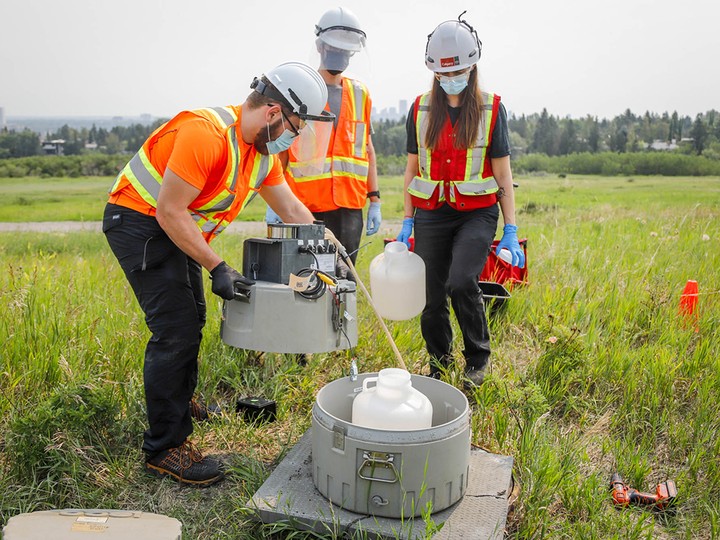  University of Calgary researchers check monitoring equipment as they track traces of COVID-19 in the wastewater system in Calgary on July 14, 2021.