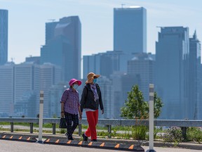 Pedestrians on the Crescent Heights pathway with lingering wildfire smoke still visible in downtown Calgary on Thursday, July 22, 2021.