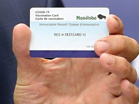 Manitoba Premier Brian Pallister holds a vaccination card during a press briefing on vaccine measures at the Manitoba Legislative Building in Winnipeg on Tues., June 8, 2021.