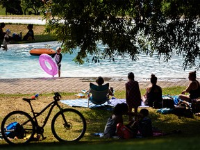 People cool down at Riley Park wading pool on a sunny morning while a heat warning is in effect in Calgary on Thursday, Aug. 5, 2021.