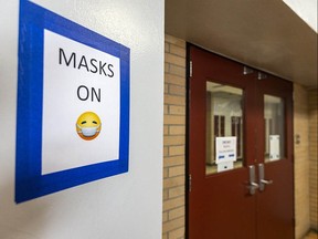 A sign reminds students and staff to keep their masks on in Henry Wise Wood High School.