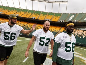 Offensive linesmen Kyle Saxelid (56), Jacob Ruby (52) and Travis Bond (58) josh during an Edmonton football practice at Commonwealth Stadium ahead of their Sept. 7 game against the Calgary Stampeders in Edmonton, on Friday, Sept. 6, 2019.