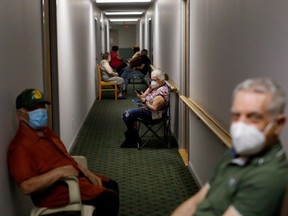 Seniors sit in the hallway following being administered their second dose of the Pfizer COVID-19 vaccine by healthcare workers from Humber River Hospital, inside Caboto Terrace, an independent seniors residence, on April 1, 2021 in Toronto, Canada.