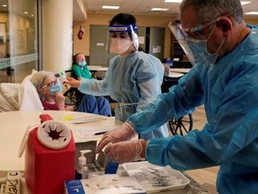 A resident at Hamilton Park Nursing and Rehabilitation, a nursing home facility, receives the Pfizer-BioNTech coronavirus disease (COVID-19) vaccine from Walgreens Pharmacists in Brooklyn, New York, U.S., January 4, 2021.