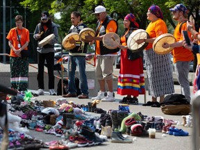 Members of the Bear Clan sing and drum at the Calgary City Hall memorial for children who did not return home from residential schools on Thursday August 26, 2021.