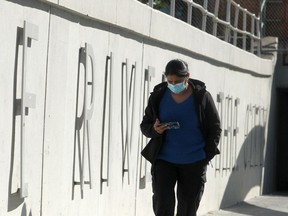 A masked pedestrian walks along 8th St. SW. Wednesday, August 25, 2021.