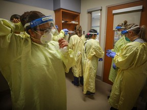 Nurses prepare to treat a COVID-19 patient on the intensive-care unit at Peter Lougheed Centre in Calgary on Nov. 14, 2020.