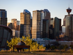 A young couple shares a romantic moment just before the sun sets behind the Calgary skyline at Scotsman’s Hill on Monday, September 20, 2021.